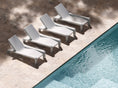 Load image into Gallery viewer, Concrete chaise lounges lined up poolside on outdoor patio
