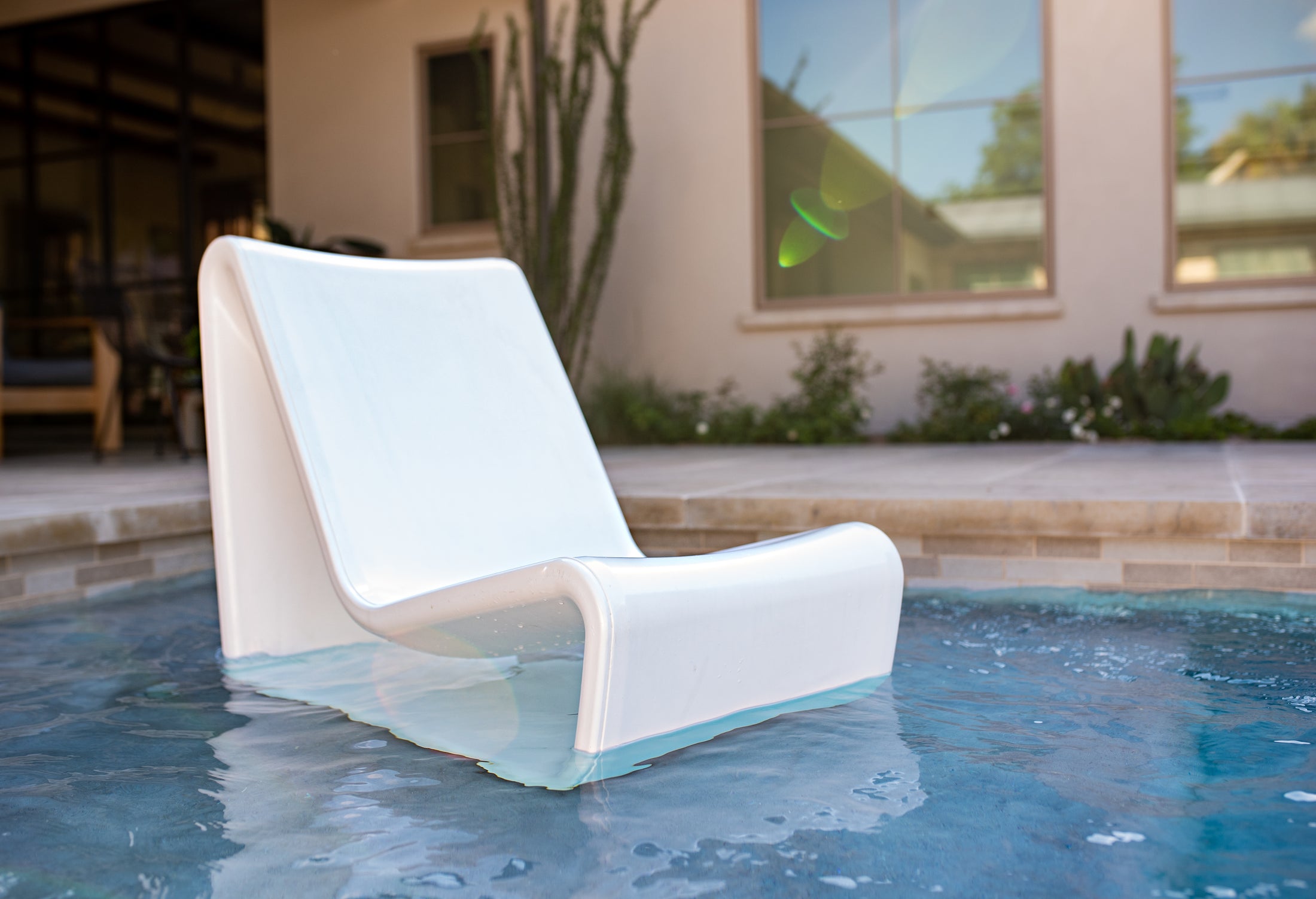 Commercial-grade white concrete in-pool lounge chair installed on a pool tanning ledge for resorts and modern outdoor spaces
